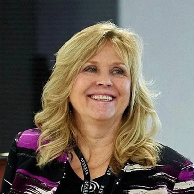 Lori Morgan smiling with blonde hair.